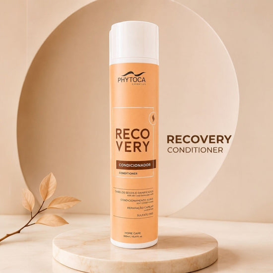 Acondicionador Phytoca USA Recovery para cabello seco y dañado en envase naranja sobre base de mármol circular.