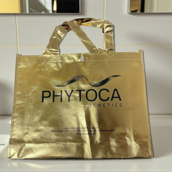 Bolsa de mano Phytoca USA de color dorado brillante con el logotipo de la marca impreso en negro