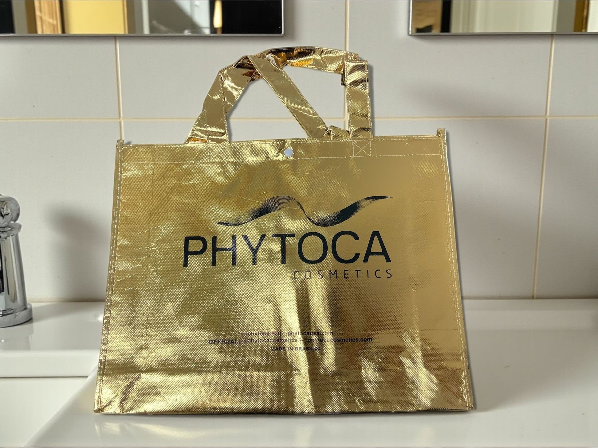 Bolsa de mano Phytoca USA de color dorado brillante con el logotipo de la marca impreso en negro