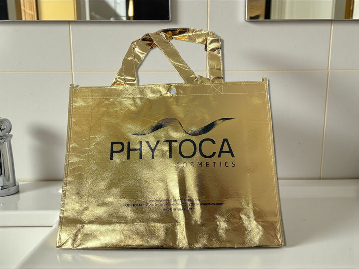 Bolsa de mano Phytoca USA de color dorado brillante con el logotipo de la marca impreso en negro