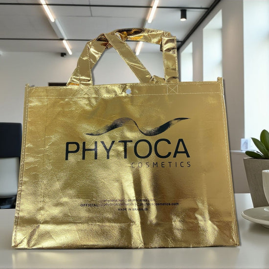 Bolsa de mano Phytoca USA de color dorado brillante con el logotipo de la marca impreso en negro
