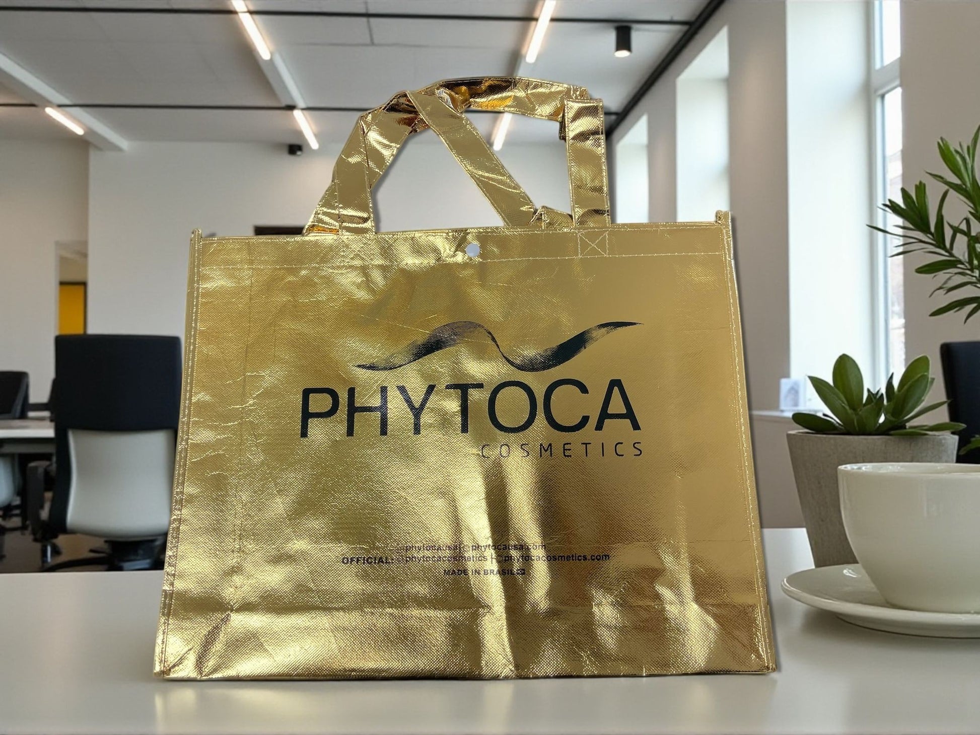 Bolsa de mano Phytoca USA de color dorado brillante con el logotipo de la marca impreso en negro