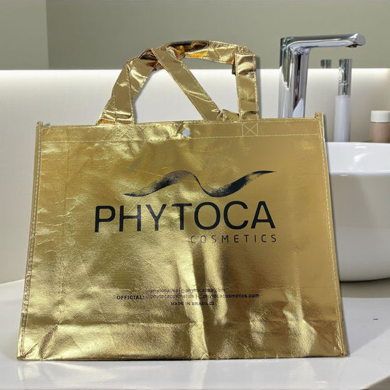 Bolsa de mano Phytoca USA de color dorado brillante con el logotipo de Phytoca Cosmetics impreso en negro.