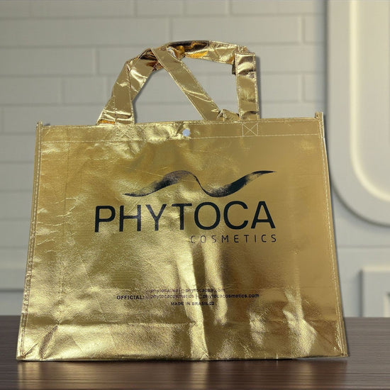 Bolsa de mano Phytoca USA de color dorado brillante con acabado metálico y logo de Phytoca Cosmetics impreso