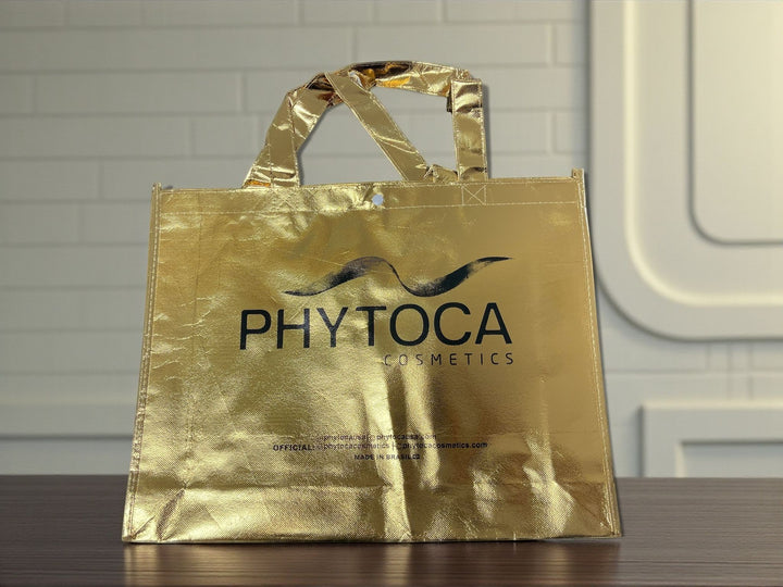 Bolsa de mano Phytoca USA de color dorado brillante con acabado metálico y logo de Phytoca Cosmetics impreso