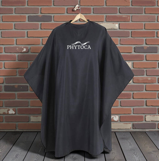 Capa de peluquería negra Phytoca USA con logo blanco, ideal para salones de belleza y protección profesional.