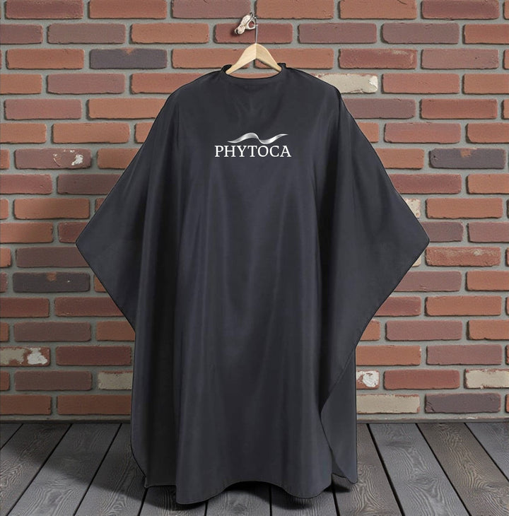 Capa de peluquería negra Phytoca USA con logo blanco, ideal para salones de belleza y protección profesional.