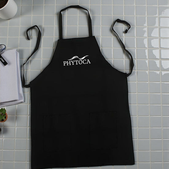 Delantal de peluquería Phytoca USA negro con bolsillos frontales y logo blanco bordado en el pecho