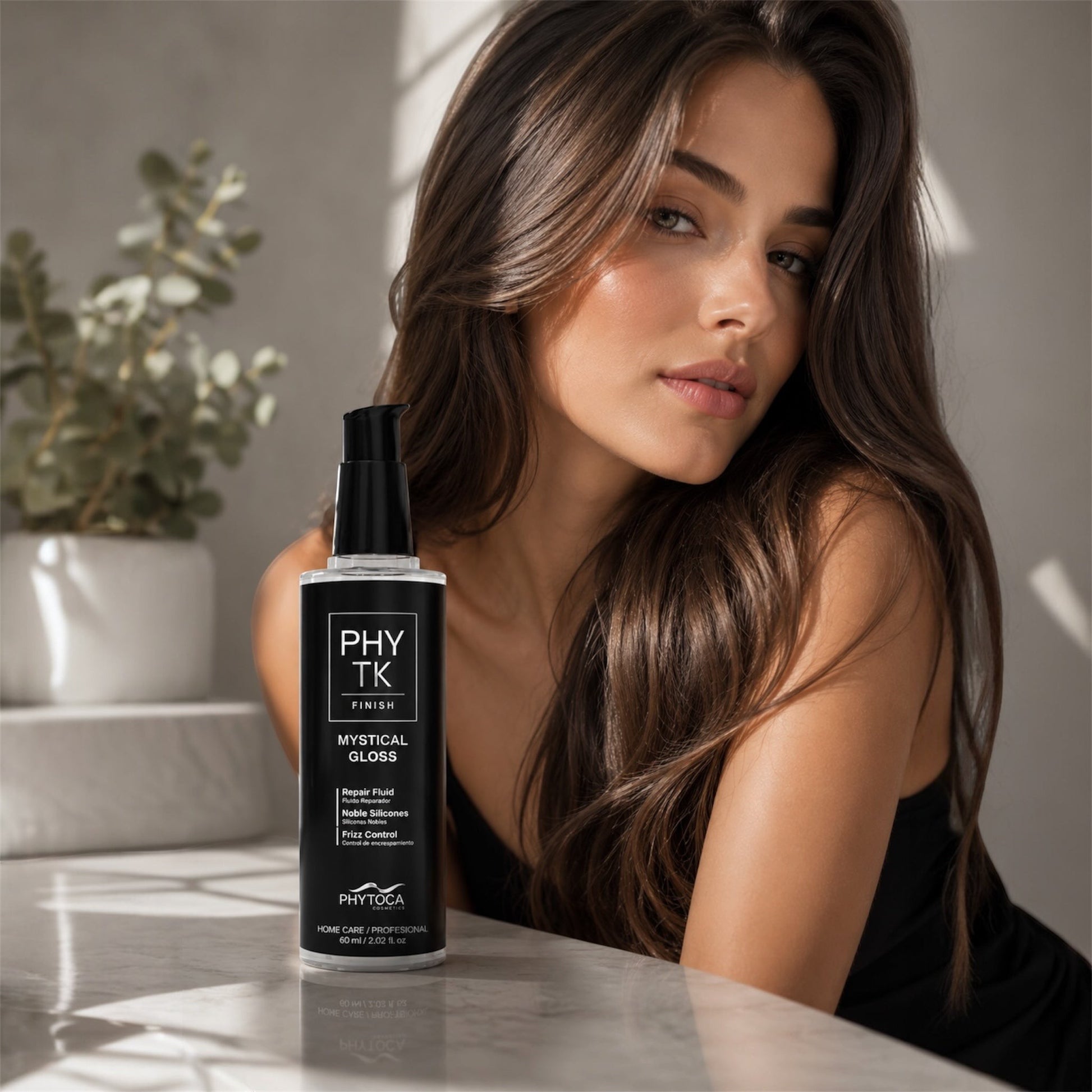 Serum capilar Phytoca USA Mystical Gloss en frasco transparente con bomba negra junto a una mujer de cabello brillante